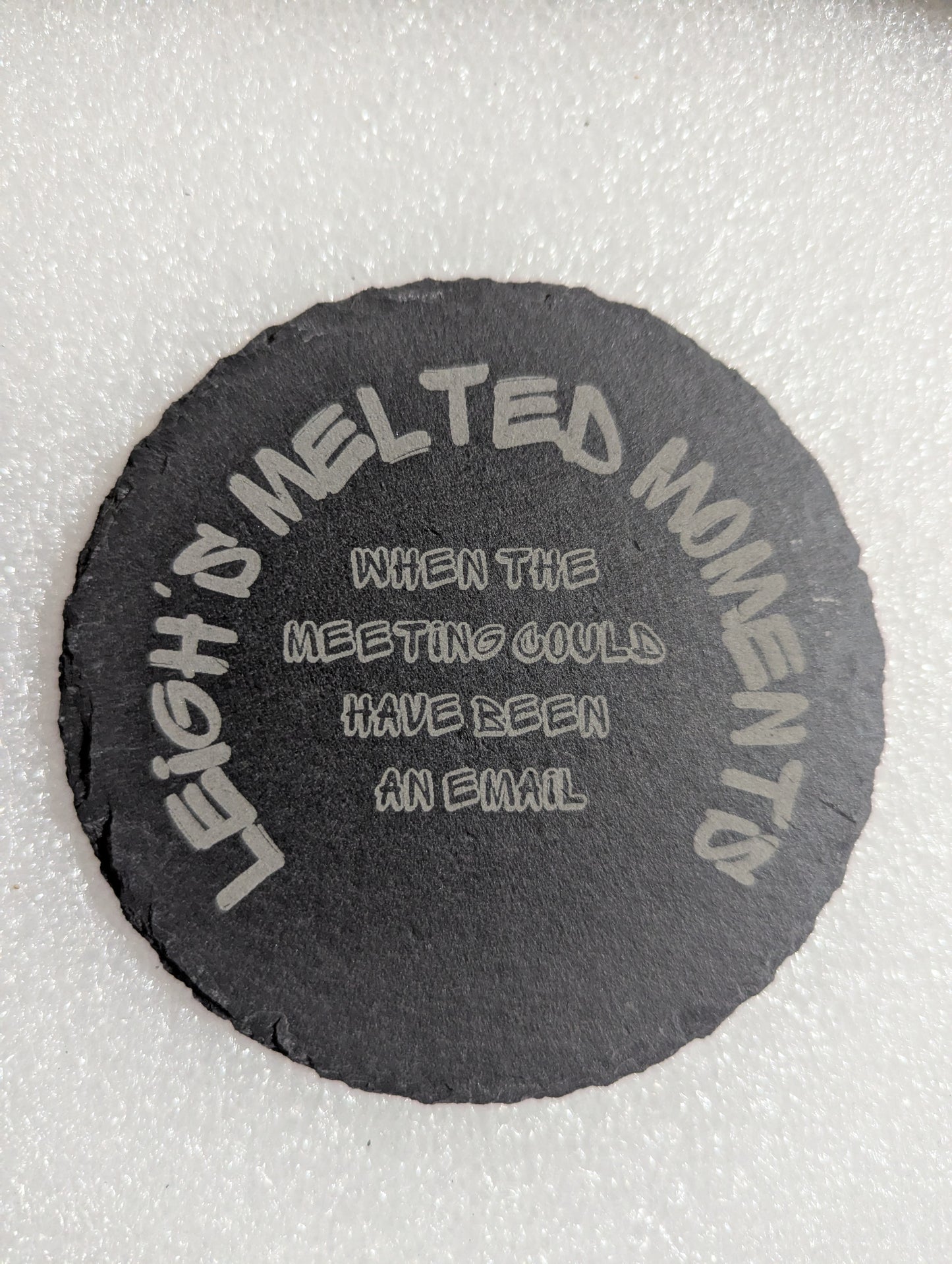 Black slate coaster engraved with the phrase 'When the meeting could have been an email' and 'Leigh's Melted Moments' branding.